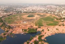 Drone view of Chandola Lake after encroachment demolition, showing cleared land and ongoing lake restoration work.