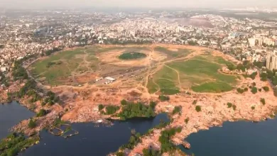 Drone view of Chandola Lake after encroachment demolition, showing cleared land and ongoing lake restoration work.