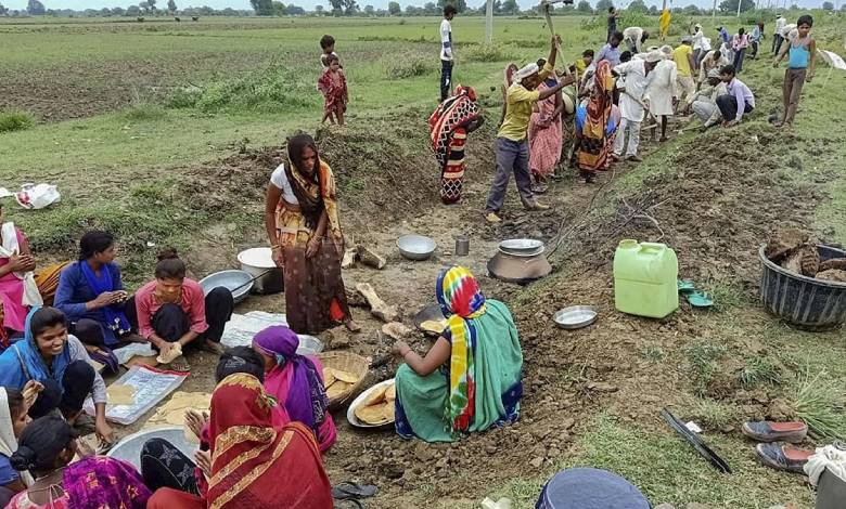 "Rural workers at MGNREGA job site as study shows declining workdays despite growing household registrations in India."