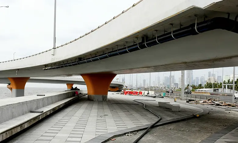 Mumbai Coastal Road promenade nearing completion, featuring lush greenery and a wide walking path by the sea.