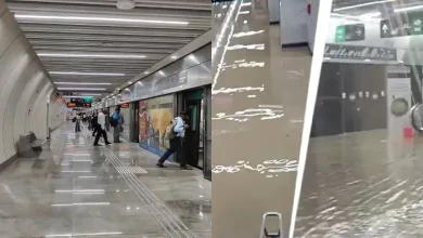 Mumbai Metro station entrance during a heavy monsoon downpour, with rain preparedness measures underway.