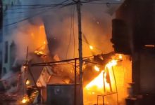 "Firefighters battling massive blaze at Washim market, Maharashtra, with thick smoke billowing from burning shops."