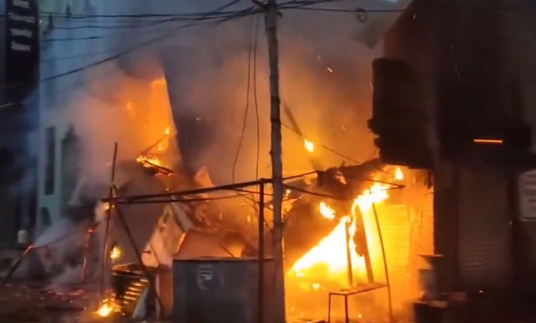 "Firefighters battling massive blaze at Washim market, Maharashtra, with thick smoke billowing from burning shops."