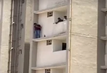 Ahmedabad suspect on apartment ledge during police standoff in kidnapping case at Shivam Aawas Yojana flats.