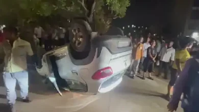 Overturned car near Khiskoli Circle, Vadodara, after late-night accident involving divider collision and traffic disruption.