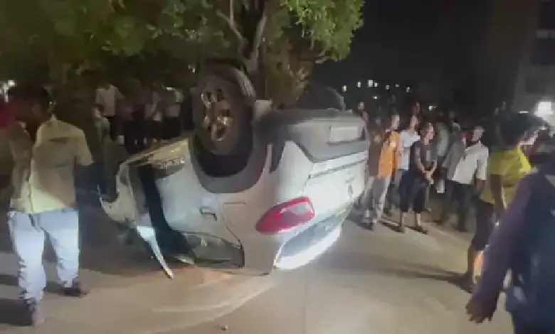 Overturned car near Khiskoli Circle, Vadodara, after late-night accident involving divider collision and traffic disruption.
