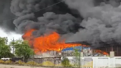 Firefighters battle massive blaze at Kheda plastic godown as thick smoke rises and nearby huts catch fire.