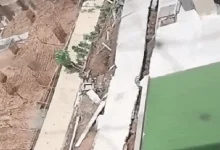 Collapsed wall of Krupal Bachpan building in Shela, Ahmedabad, with nearby excavation work sparking safety concerns.