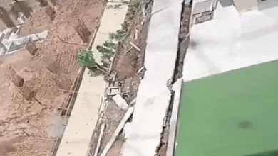Collapsed wall of Krupal Bachpan building in Shela, Ahmedabad, with nearby excavation work sparking safety concerns.
