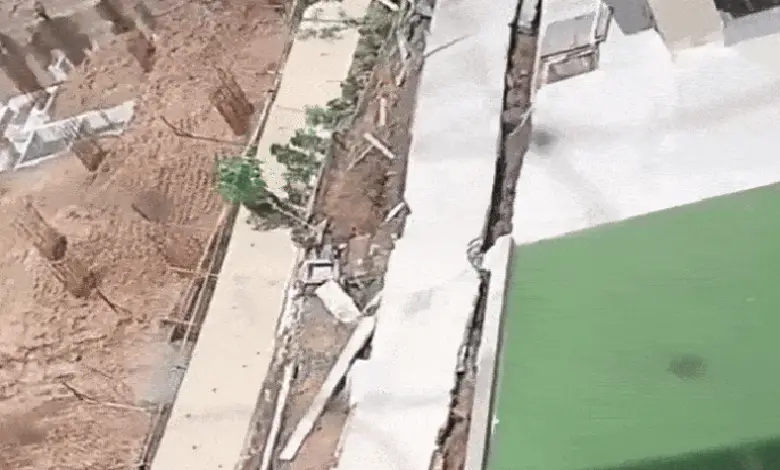 Collapsed wall of Krupal Bachpan building in Shela, Ahmedabad, with nearby excavation work sparking safety concerns.