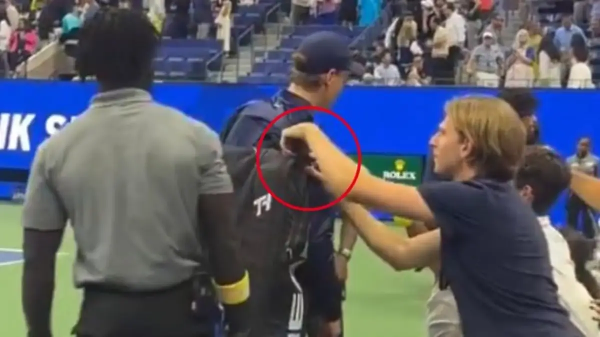 World No. 1 tennis star tries to hand a towel to a fan; another spectator attempts to steal from his kit!